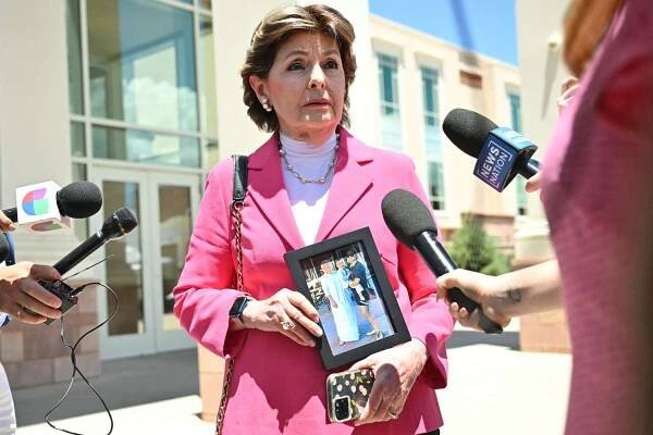 Attorney Gloria Allred holds an image of the Hutchins family as she speaks to the press on July 10, 2024 in Santa Fe, New Mexico.