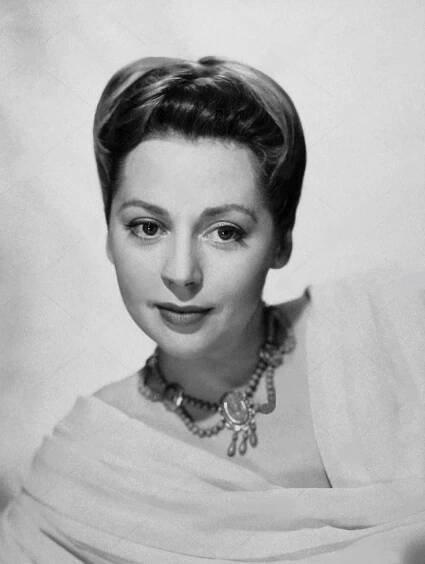 an old black and white photo of a woman in a dress with pearls on her necklace