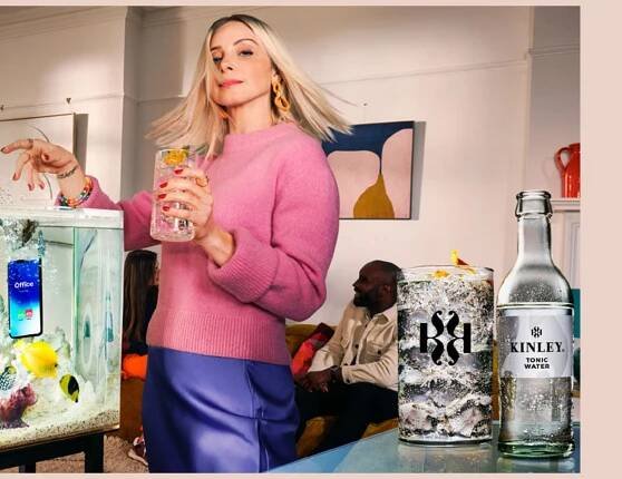 Banner, auf dem mehrere Menschen in einem Raum zu sehen sind, die sich unterhalten. Im Vordergrund eine Frau mit einem Glas in der Hand. Rechts im Bild eine Flasche Kinley Tonic Water und ein gefülltes Glas. Links oben der Text „Es ist deine Zeit. Geniesse sie! You owe it to yourself.“, links unten der Kinley-Schriftzug.