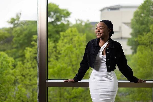 Monique Johnson poses for a portrait in front of the large windows in Warch Campus Center.