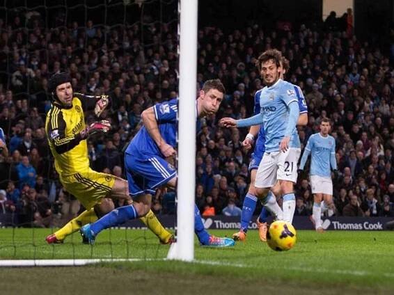 Brankář Chelsea Petr Čech (vlevo) proti nepřesné střele Davida Silvy z Manchesteru City zasahovat nemusel.