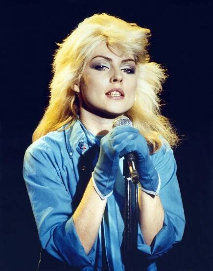 Debbie Harry in blue onstage. 