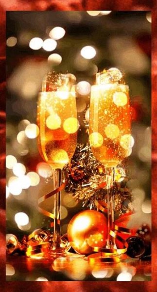 two glasses of champagne sitting on top of a table next to a christmas ornament