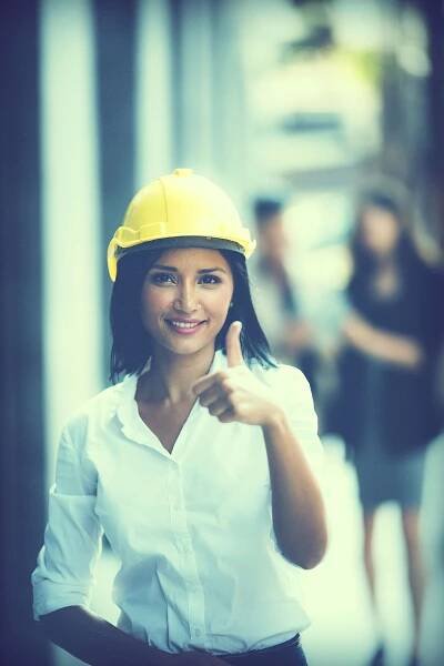 Image of a woman on work site in a hard hat