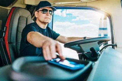 英俊中年男人的画像,专业卡车司机坐着开着大卡车.4.他在开车的时候用智能手机和别人说话是很危险的. — 图库图片#