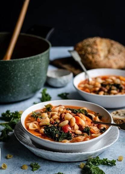 minestrone with kale and beans in bowls with bread
