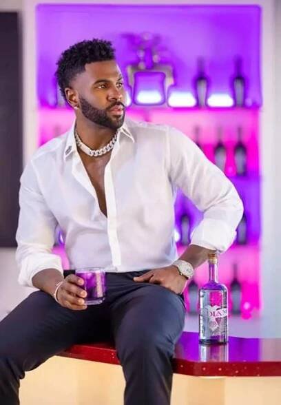 a man sitting on top of a table next to a bottle