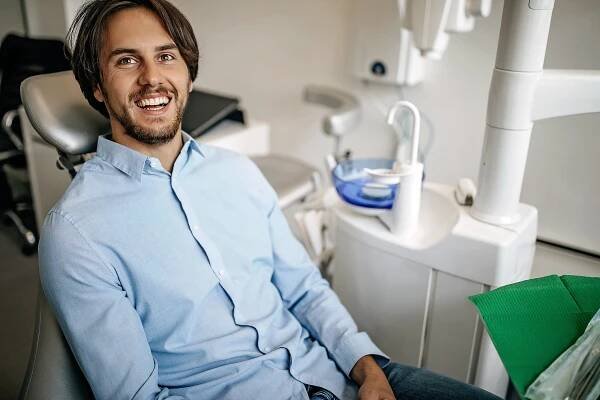 smiling woman at dentist office with dental staff in background