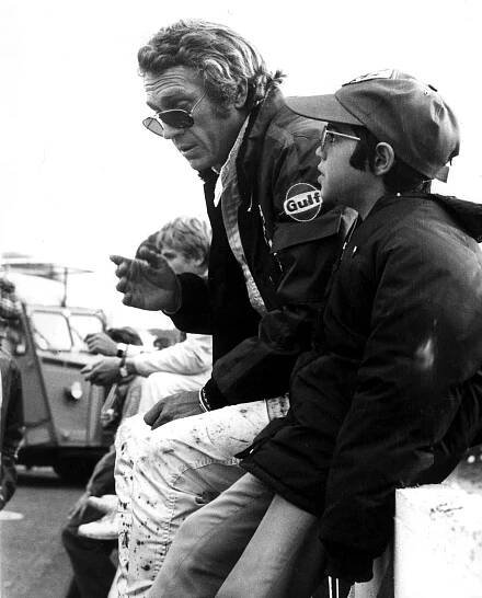 a man wearing a gulf jacket talks to a young boy