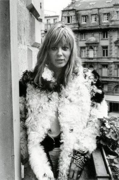 a black and white photo of a woman wearing a fur coat