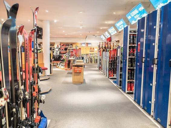 Innenansicht eines Skigeschäfts mit Skiern, Stiefeln und Schildern