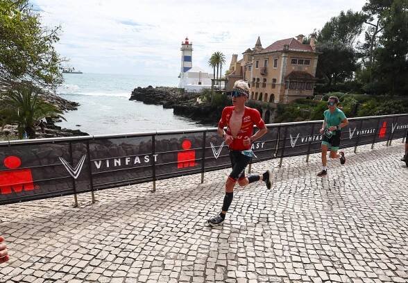 IM Portugal athletes running with lighthouse in the background