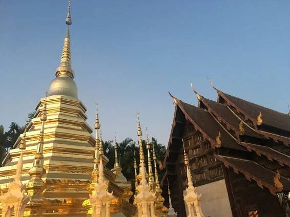 Photo of shining gold stupa and temple at sunset Wat Phan Tao in Chiang Mai, Thailand