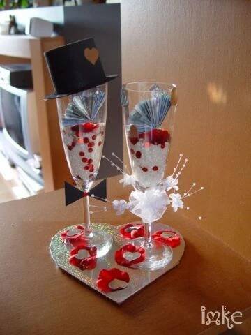 two wine glasses sitting on top of a table next to each other with hearts in them
