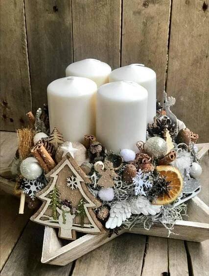 three white candles sitting on top of a star shaped tray filled with christmas decorations and ornaments