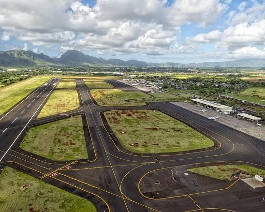 A tarmac dotted with green patches in between the runways and ramps.