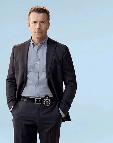 Confident Manin Suitwith Badge Wallpaper