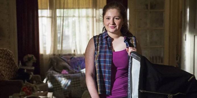 Emma Kenney as Debbie in 'Shameless' standing in front of an open suitcase