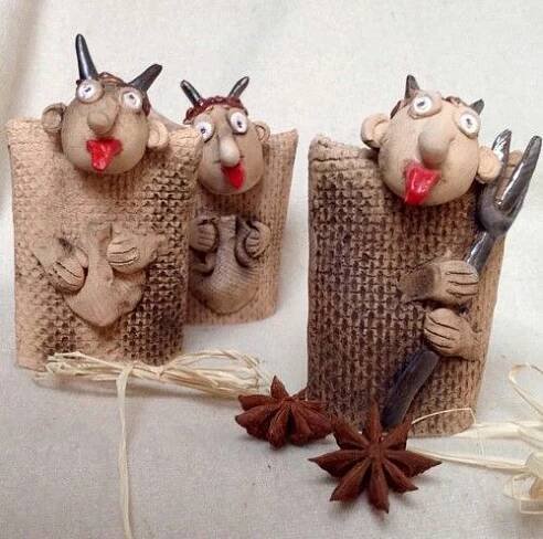 three small sculptures made out of burlocks with horns on their heads and hands