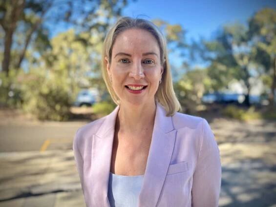 A woman in a light-coloured blazer.