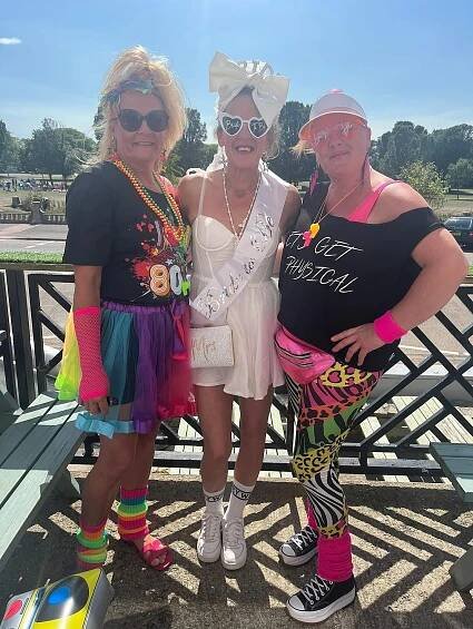 Three women in 1980s-themed attire at a hen party.