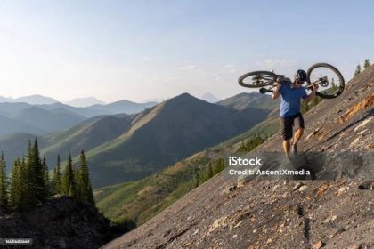 Muž na horském kole nese kolo do strmého svahu - Bez autorských poplatků Nepřízeň osudu - Pojem Stock fotka