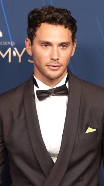 Cooper Koch wore custom Calvin Klein Collection to the 77th Primetime Emmy Awards.

Seen in a dark brown wool double-breasted shawl collar tuxedo, bowtie and white micro-pleated plastron poplin tuxedo shirt. Punctuated by brown leather derbies. 