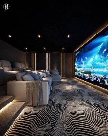 a large screen in the middle of a room with couches and pillows on it