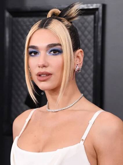 Dua Lipa with porcelain skin and bright blue halo-inspired eyeshadow
