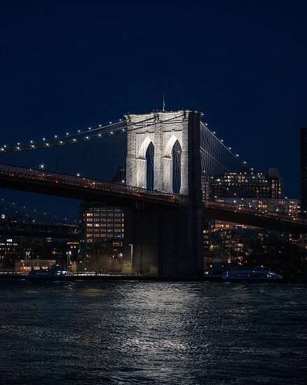 the brooklyn bridge is lit up at night