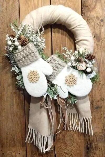 a wreath with white mitts and pine cones on it