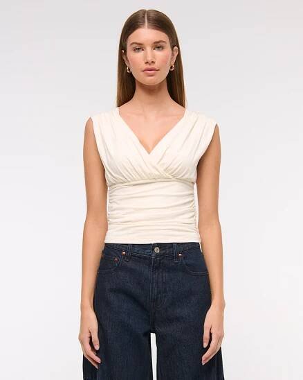 A model wearing the Abercrombie & Fitch Ruched V-Neck Top in white