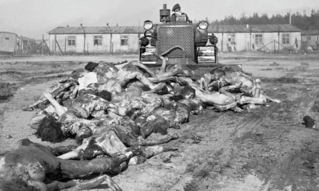 Britský armádní buldozer při práci: Hrnutí mrtvých těl do hromadného hrobu, bývalý KT Bergen-Belsen, 19. duben 1945