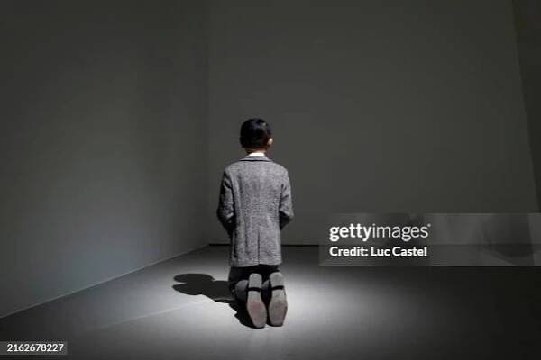 Him, a realistic model of a kneeling schoolboy with the head of Adolf Hitler created by artist Maurizio Cattelan, is displayed at Bourse de Commerce...