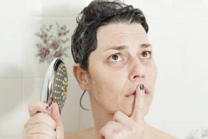 žena s náporem myšlenek na sprchu při mytí vlasů