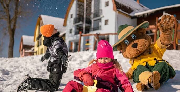 Děti na sněhu před apartmány Landal Marina Lipno
