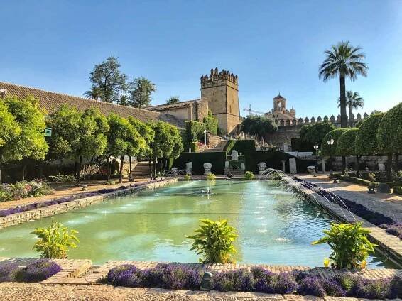 Andalusia Jardines Del Alcazar Pool With Water Jets And Flowers In Front Of Castle