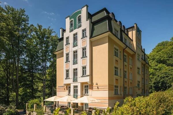 a building with umbrellas in front of it at Spa & Wellness Hotel Silva in Mariánské Lázně