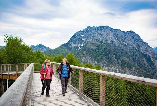 Zwei Frauen wandern den Holzpfad entlang