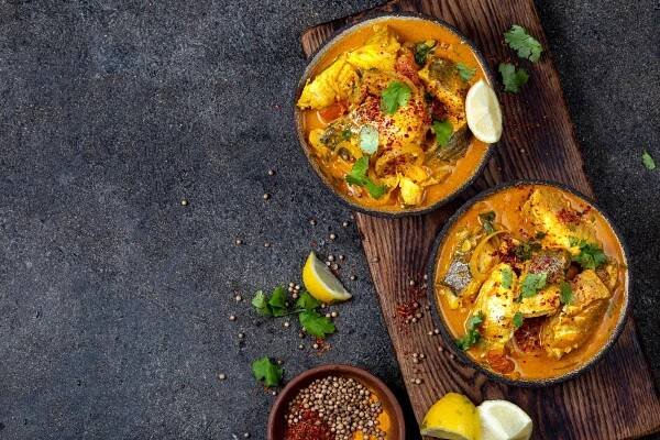 indické jídlo. tradiční kerala fish curry s naanovým chlebem, šedý talíř, černé pozadí - kari - stock snímky, obrázky a fotky