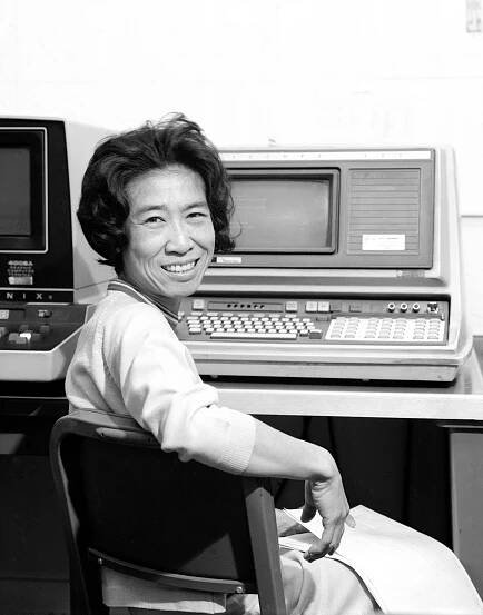 Helen Ling, seated in ¾ profile to the right, in front of a 1970s computing unit