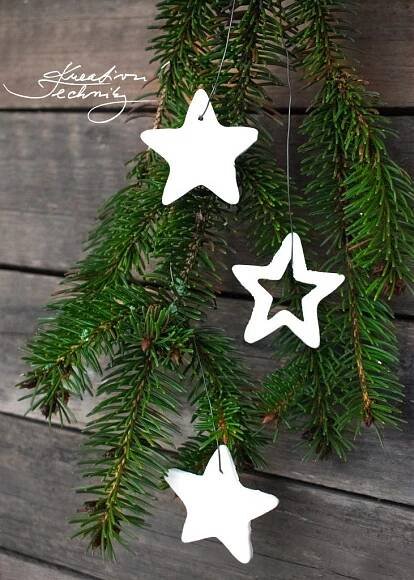 three white stars hanging from a tree branch