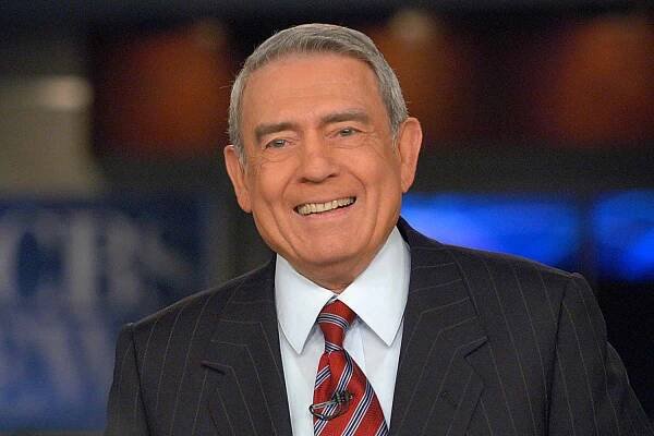 an older man in a suit and tie smiles for the camera while wearing a red striped tie