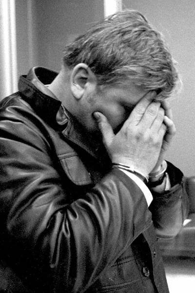 At the Des Plaines police station, John Wayne Gacy covers his face with his manacled hands as he emerged after an all-night questioning session on Dec. 22, 1978.