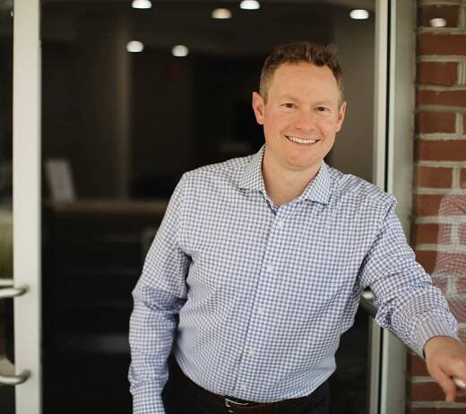 Dr. Heffernan standing outside the door of his dental practice
