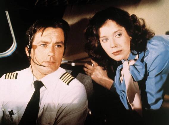 a man wearing a headset stands next to a woman wearing a tie