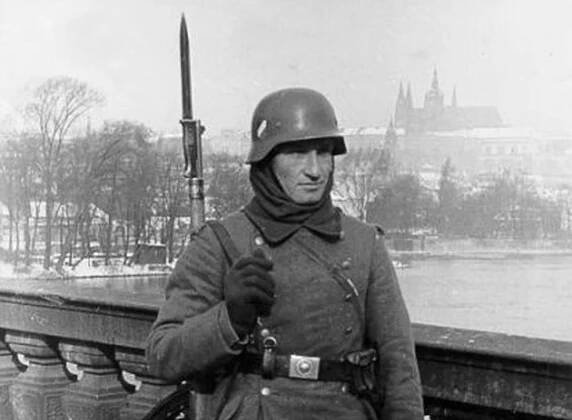 Příslušník říšské branné moci na Mostě Legií v pozadí se symbolem české státnosti – chrámem sv. Víta, 15. 3. 1939 (zdroj: J. B. Uhlíř, kniha Protektorát Čechy a Morava)