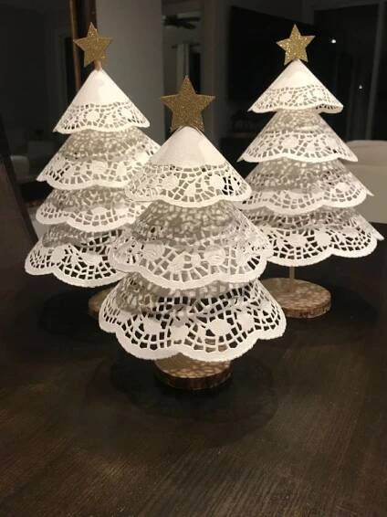 three small white christmas trees sitting on top of a wooden table