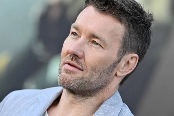 Joel Edgerton posing in a blue suit at the premiere of Prime Video's 