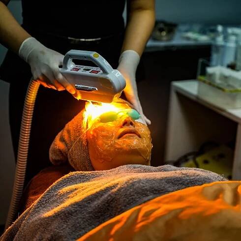 A lady receiving a laser treatment by a professional